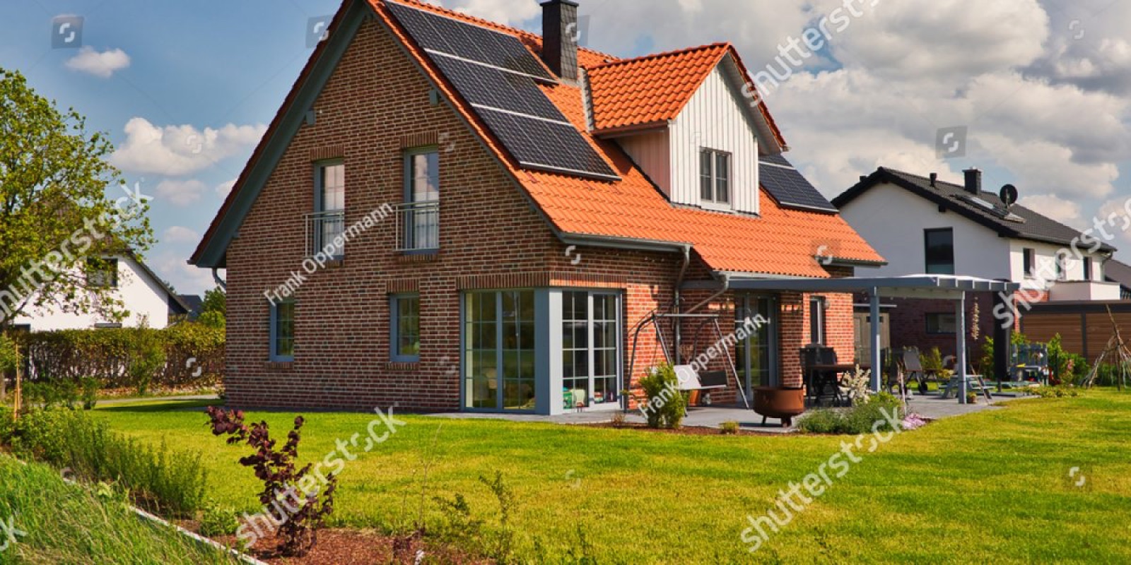 Modernes Einfamilienhaus mit Solaranlage und begrüntem Garten